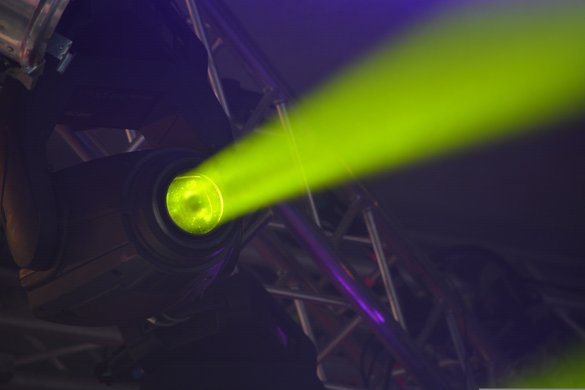 Scheinwerfer an einer Traverse mit grünem Lichtstrahl.